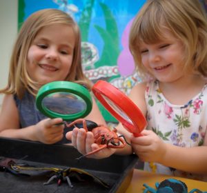 Two children playing with magnifying glasses