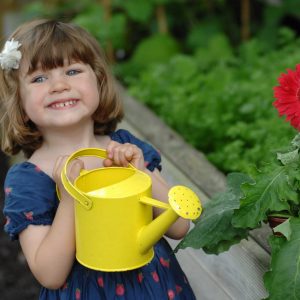 Child watering plants in the garden